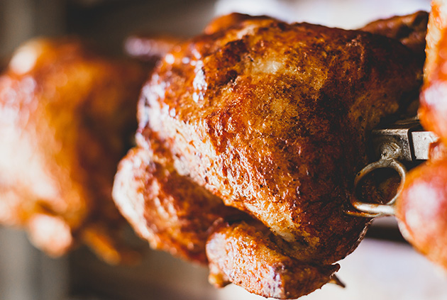 Rotisserie for grill rotating multiple whole chickens for juicy tender meat.